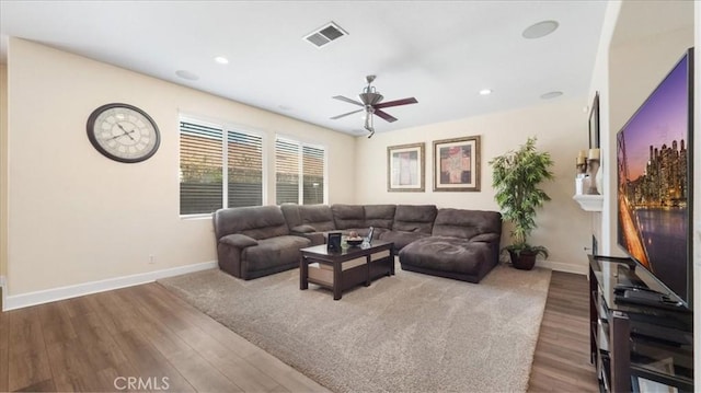 living room with a ceiling fan, wood finished floors, visible vents, and baseboards