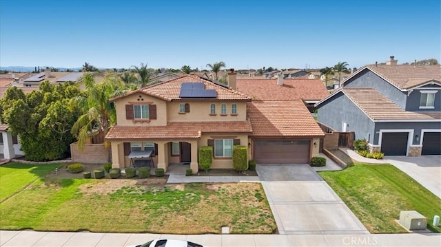 view of front of home with driveway, solar panels, stucco siding, a front lawn, and a tiled roof