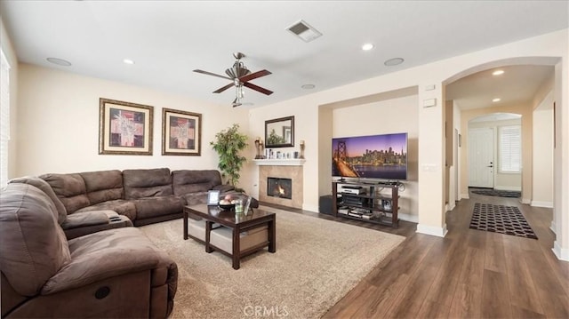 living area with visible vents, recessed lighting, a glass covered fireplace, and dark wood-style flooring