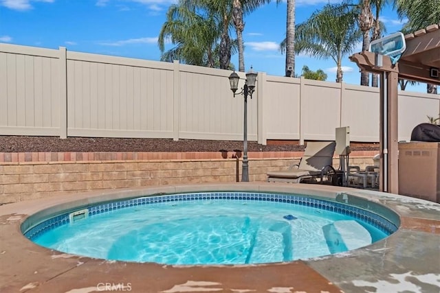 view of swimming pool featuring an in ground hot tub and fence