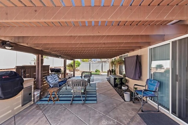 view of patio featuring a grill and fence