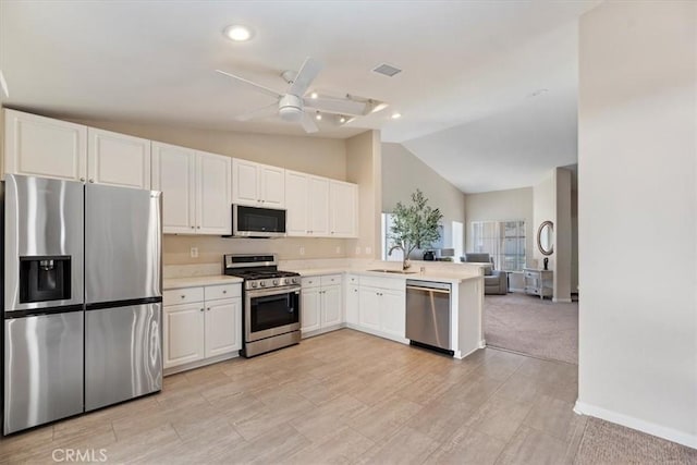 kitchen with stainless steel appliances, light countertops, a sink, and white cabinetry