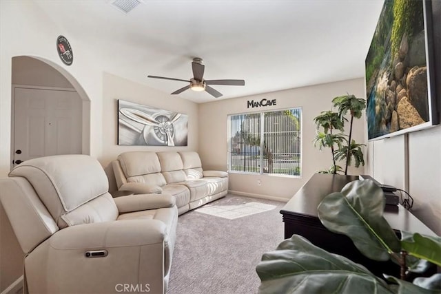 carpeted living room with baseboards, visible vents, and a ceiling fan