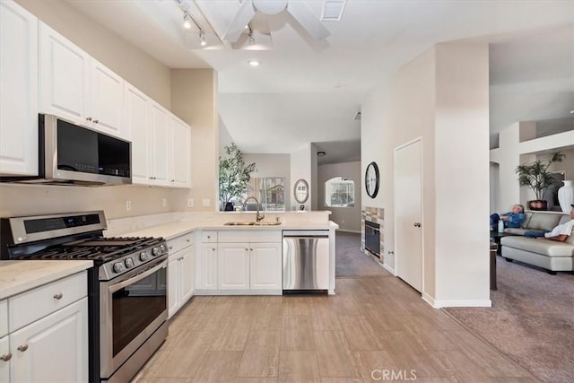 kitchen featuring light countertops, appliances with stainless steel finishes, a sink, and white cabinets