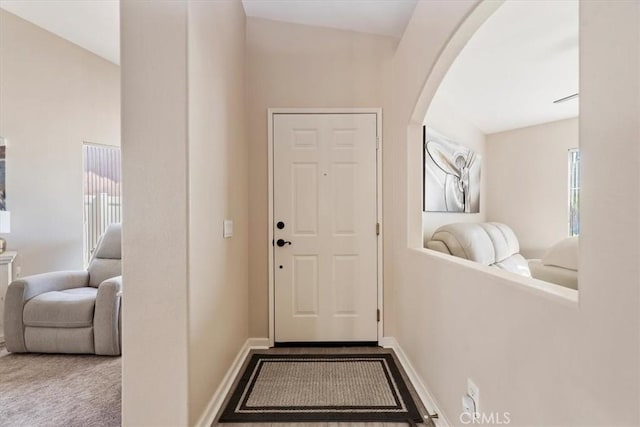 interior space featuring a wealth of natural light, arched walkways, and baseboards