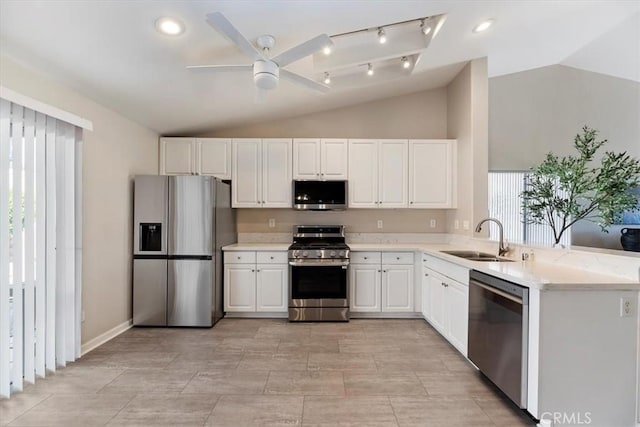 kitchen featuring stainless steel appliances, lofted ceiling, light countertops, and a sink