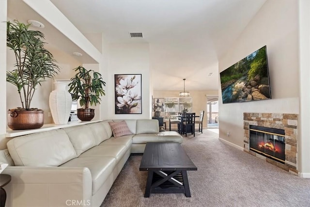 living room featuring carpet floors, visible vents, a stone fireplace, and baseboards