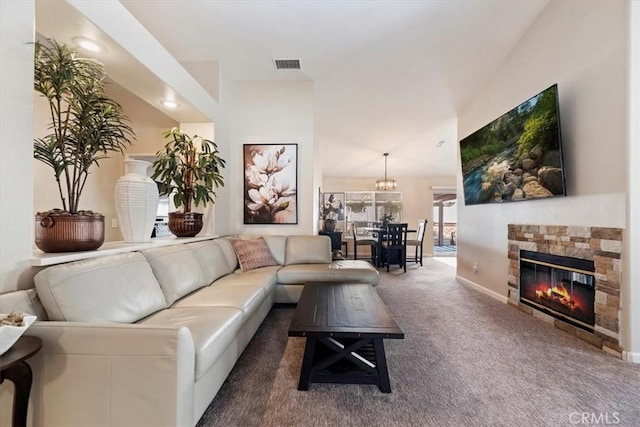 carpeted living room featuring a stone fireplace, visible vents, and baseboards