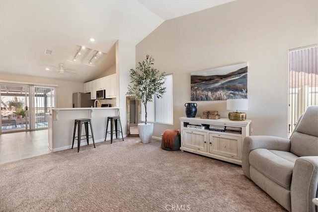 living area featuring light colored carpet, visible vents, ceiling fan, high vaulted ceiling, and baseboards