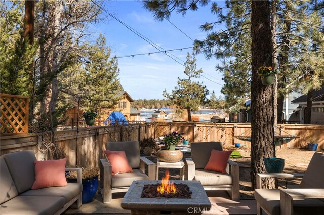 view of patio / terrace with a fenced backyard and an outdoor living space with a fire pit