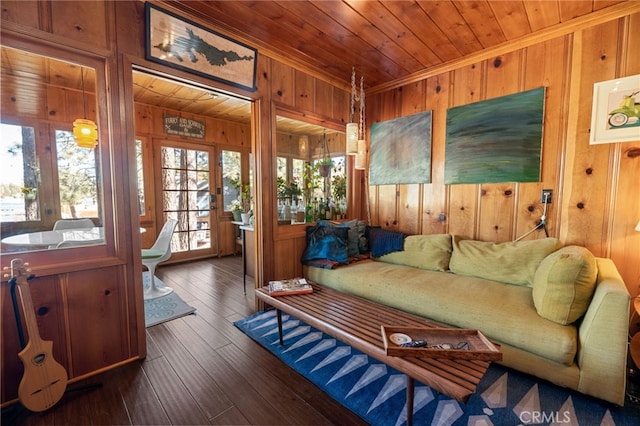 living area with ornamental molding, wooden ceiling, wood walls, and wood-type flooring