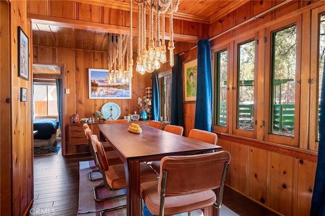 dining area featuring wooden ceiling, wood walls, wood-type flooring, and an inviting chandelier