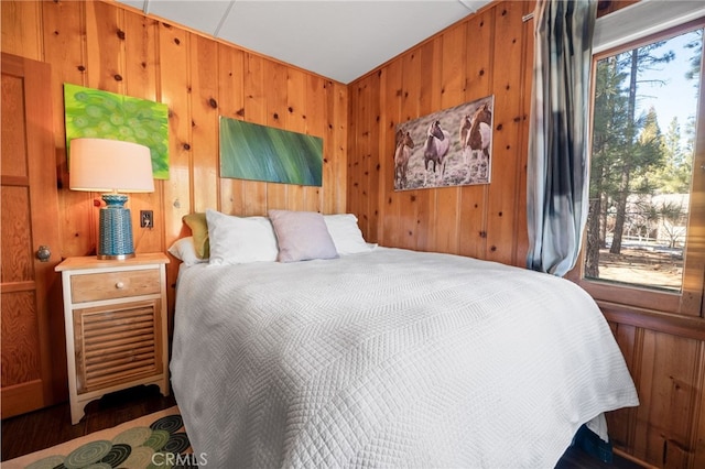 bedroom featuring wood walls and multiple windows