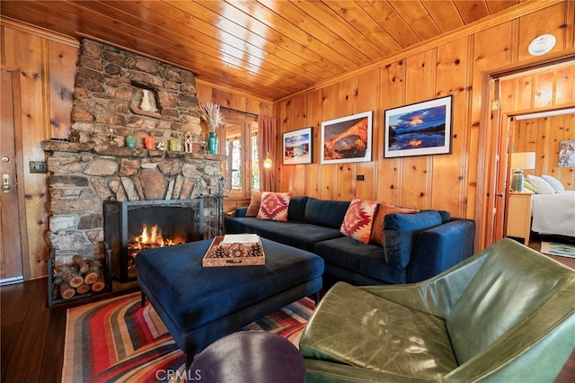 living room featuring wooden ceiling, a fireplace, wooden walls, and wood finished floors