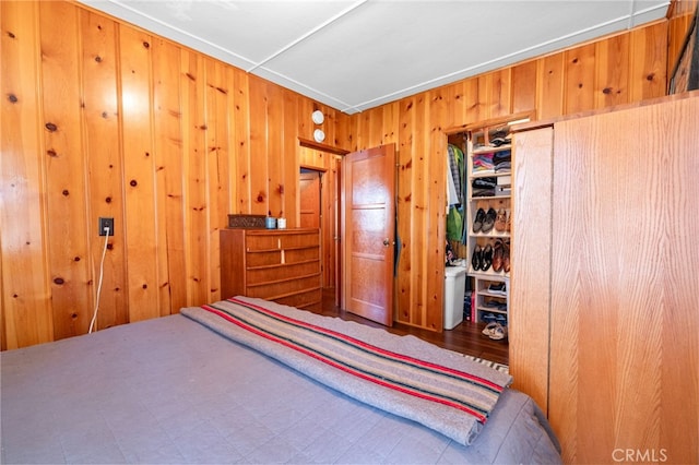 bedroom featuring a closet and wooden walls