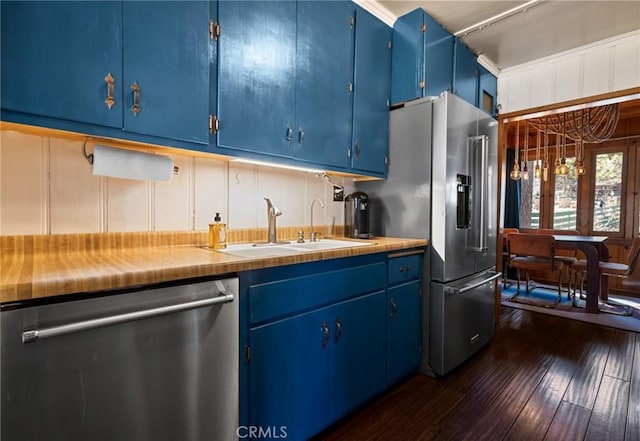 kitchen featuring blue cabinets, stainless steel appliances, dark wood-style flooring, a sink, and light countertops