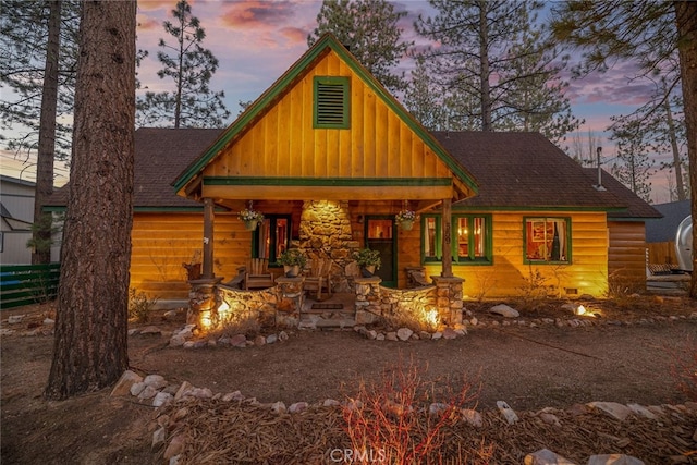 view of front of home with a shingled roof and fence