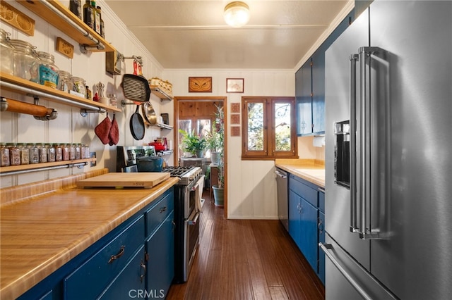 kitchen with blue cabinets, stainless steel appliances, ornamental molding, and dark wood-style floors