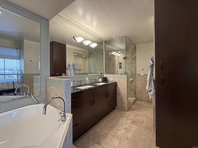 full bath featuring a bathing tub, double vanity, a stall shower, a sink, and tile walls