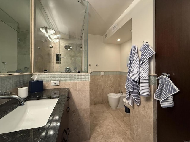 bathroom featuring vanity, a bidet, visible vents, tiled shower, and tile walls