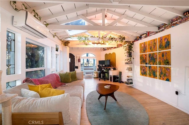 living area featuring an AC wall unit, light wood-style floors, and lofted ceiling with skylight