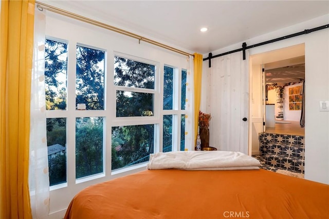 bedroom featuring a barn door and recessed lighting