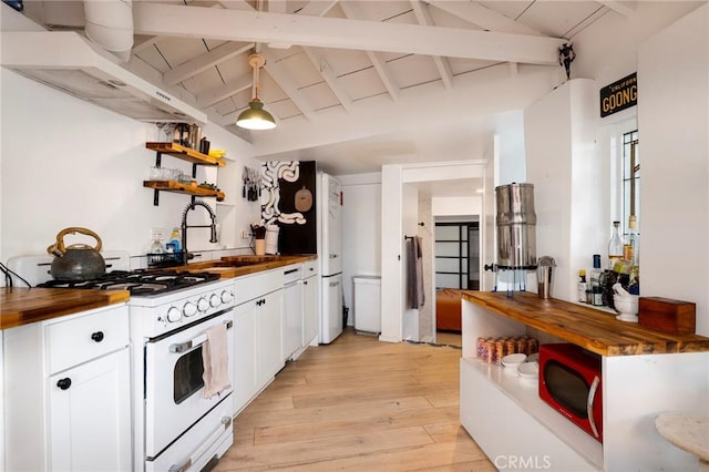 kitchen featuring light wood-type flooring, white gas stove, open shelves, lofted ceiling with beams, and wooden counters