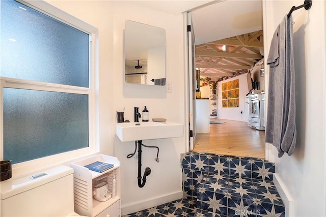 bathroom featuring tile patterned floors, toilet, baseboards, and a sink