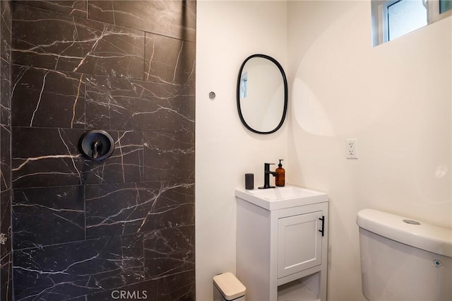 bathroom featuring toilet, vanity, and walk in shower