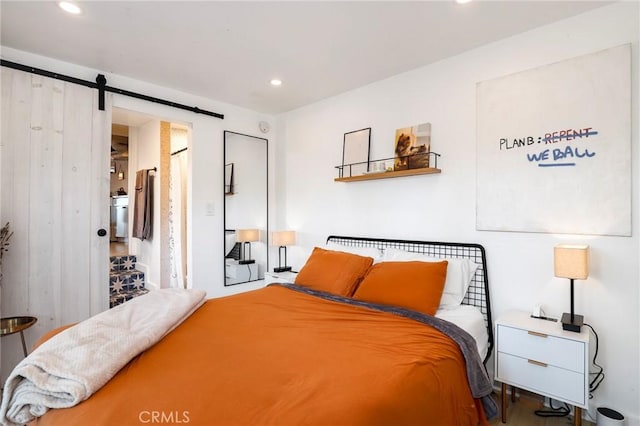 bedroom featuring recessed lighting and a barn door