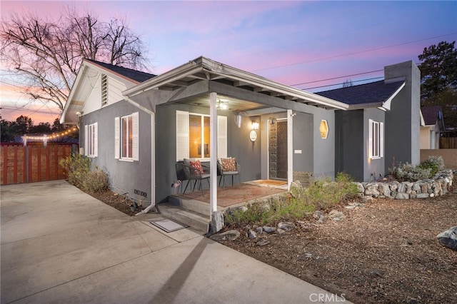 view of front of house featuring fence and stucco siding