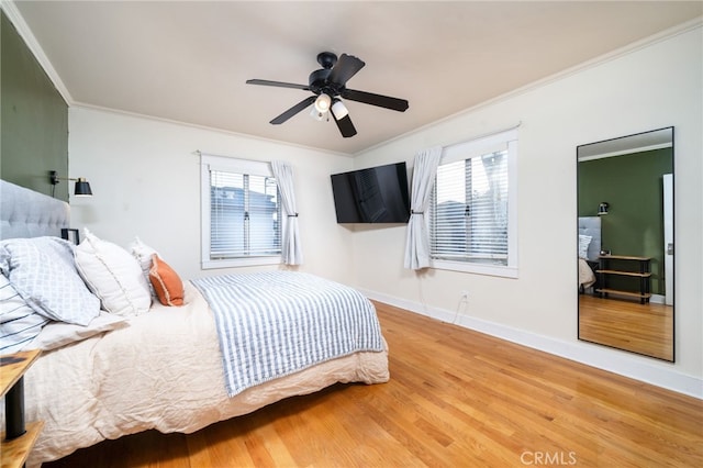 bedroom featuring crown molding, baseboards, and wood finished floors