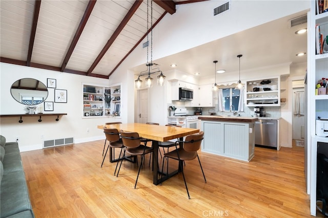 dining space with baseboards, light wood-style flooring, visible vents, and beamed ceiling