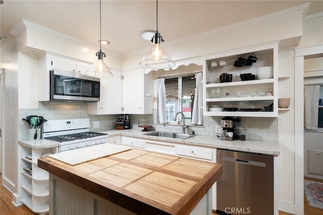 kitchen featuring stainless steel appliances, hanging light fixtures, open shelves, and a center island