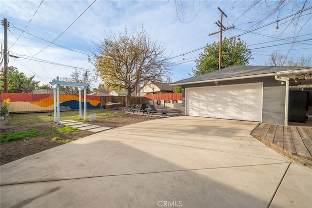 exterior space featuring an outbuilding, fence, and a garage