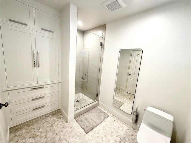 full bathroom featuring a stall shower, baseboards, visible vents, and toilet