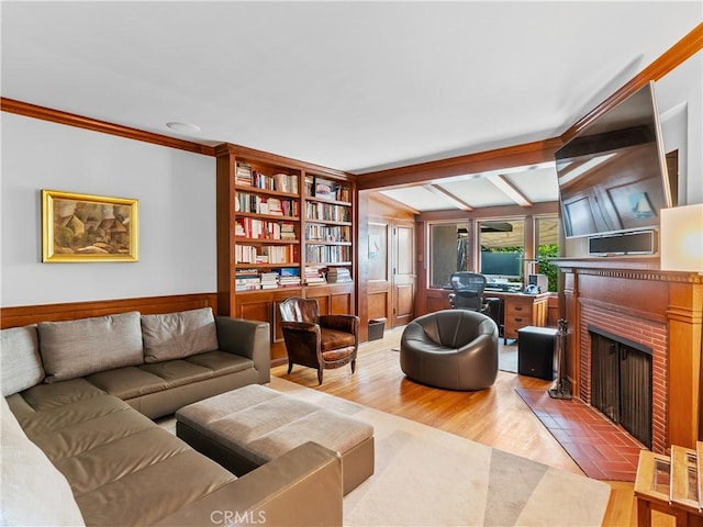 living room featuring vaulted ceiling with beams, a brick fireplace, and wood finished floors