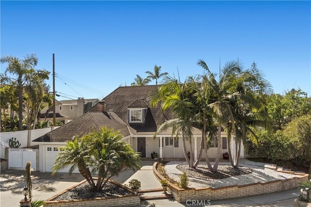 view of front of house featuring driveway, a garage, and fence