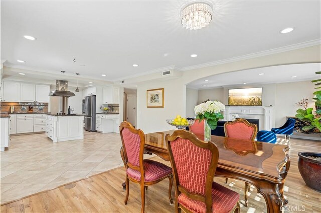 1632 Indus St, Newport Beach, CA 92660 - dining space with recessed lighting, crown molding, a fireplace, arched walkways, and light wood-style flooring