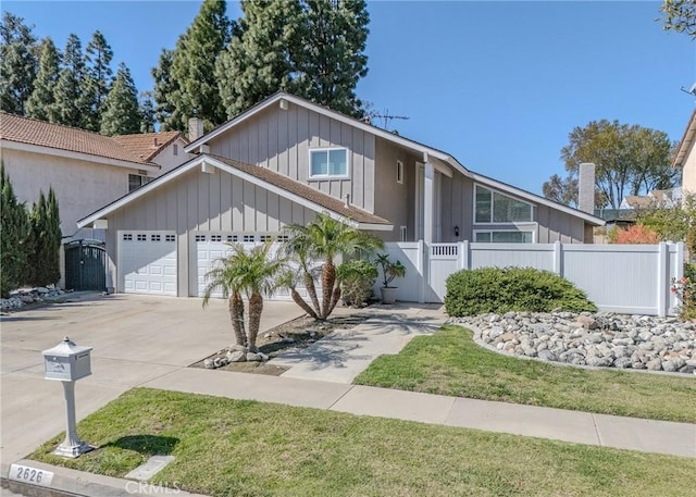 view of front facade featuring a gate, fence, driveway, and an attached garage