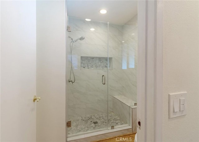 bathroom with a shower stall and recessed lighting