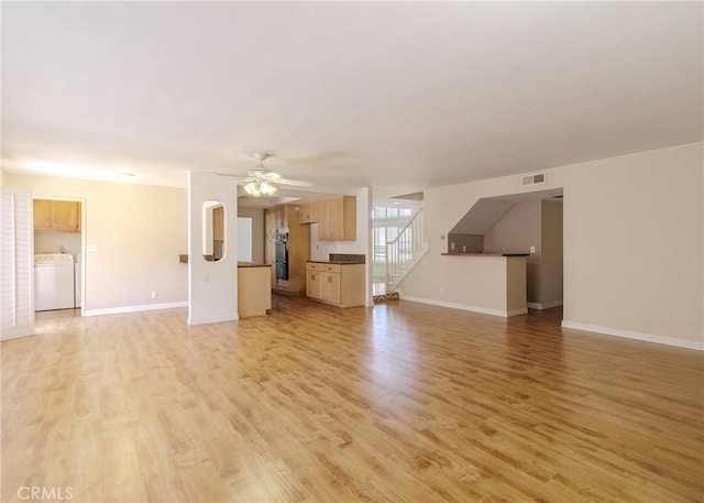 unfurnished living room featuring ceiling fan, visible vents, baseboards, light wood-type flooring, and washer / clothes dryer