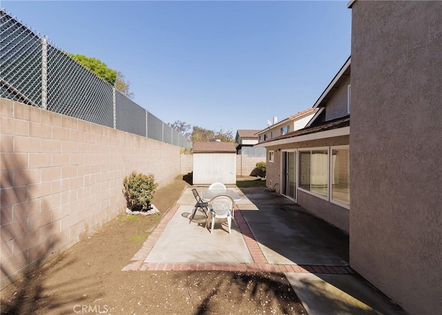 view of patio featuring an outbuilding, a shed, and a fenced backyard