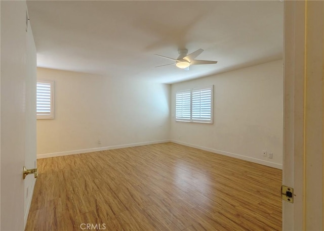 spare room with ceiling fan, baseboards, and wood finished floors