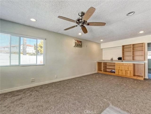 unfurnished living room featuring recessed lighting, carpet flooring, a textured ceiling, and baseboards