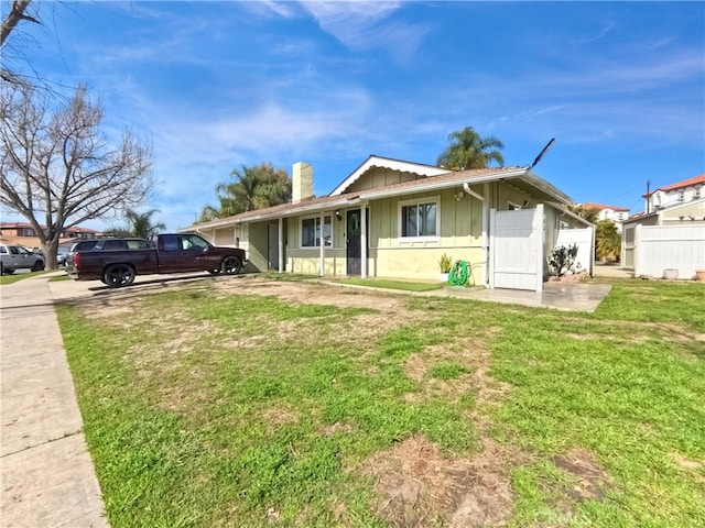 ranch-style home with concrete driveway, board and batten siding, and a front yard