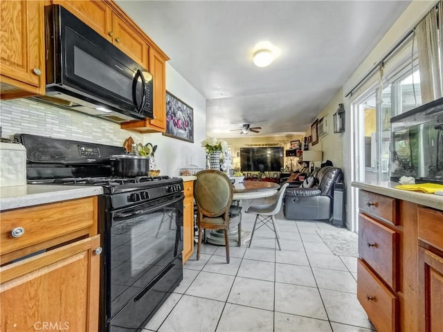 kitchen featuring decorative backsplash, brown cabinets, open floor plan, light countertops, and black appliances