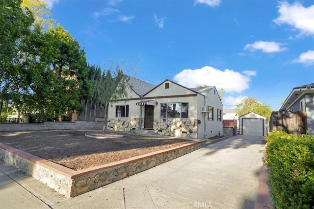 view of front of property with driveway, stucco siding, a garage, and an outbuilding