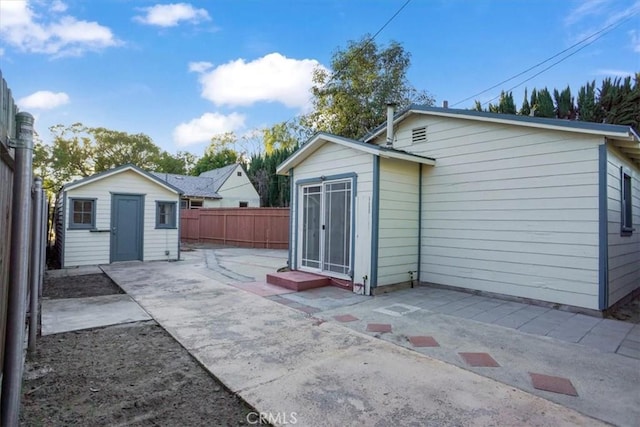 exterior space with a patio area, fence, and an outdoor structure