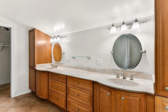 full bath with vaulted ceiling, double vanity, a sink, and tile patterned floors